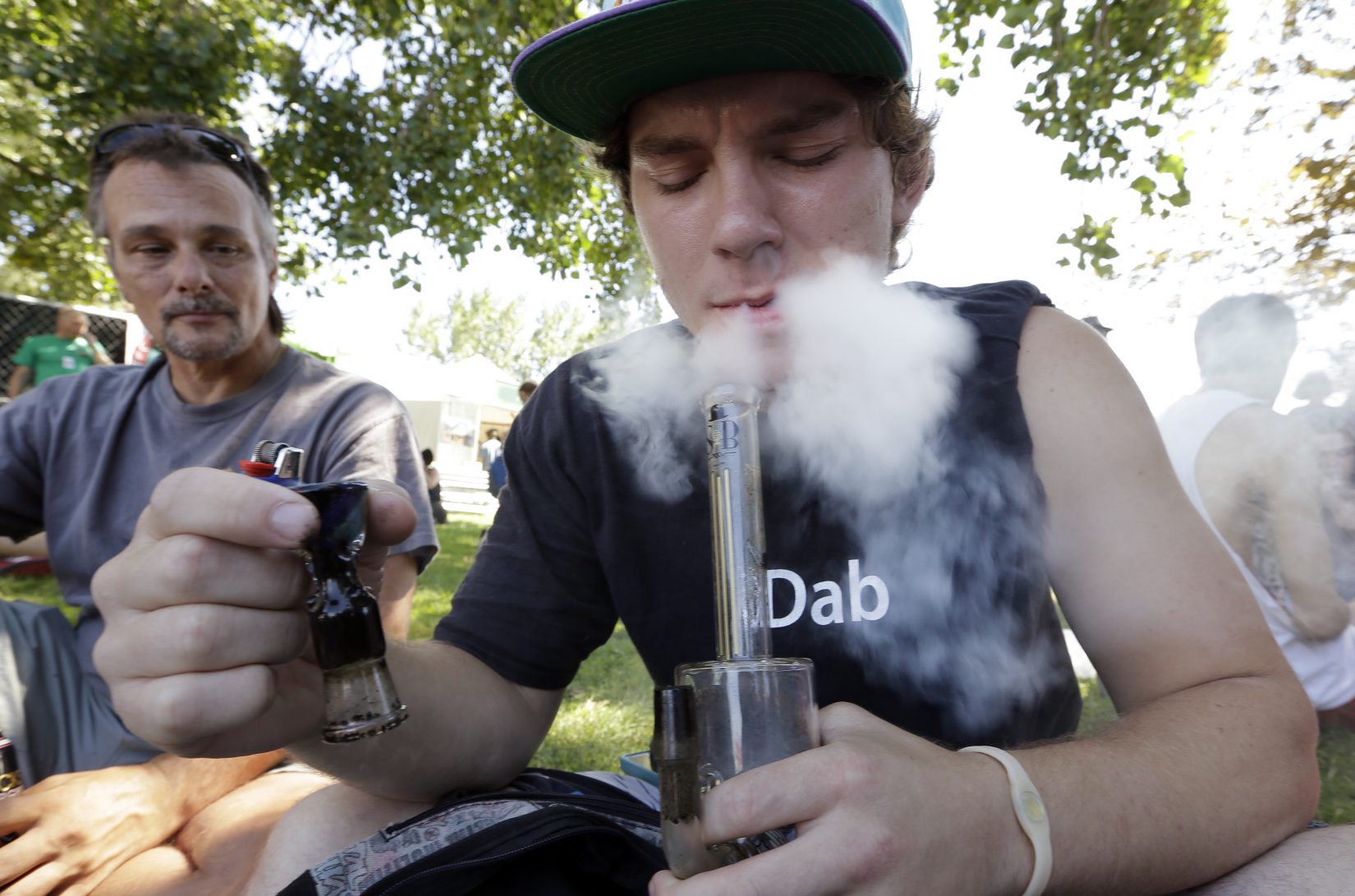 In this Aug. 16, 2013, file photo, Cody Park exhales a cloud of marijuana smoke after taking a hit on a bong at the first day of Hempfest in Seattle. A new study by the Rand Corp. suggests the market for marijuana in Washington state could be more than twice what state officials estimated last year, before voters approved Initiative 502 to set up a regulated system of recreational marijuana sales to adults. (AP Photo/Elaine Thompson, File)