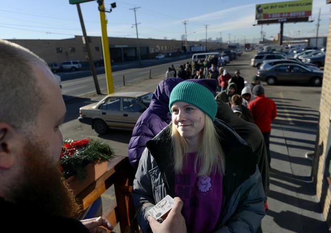 Kurt Britz checks Kristin Brinckerhoff's identification outside 3D Cannabis Center in Denver on Thursday, the second day of legal sales of recreational marijuana in Colorado. Brinckerhoff waited a day because, she said, "I just knew the lines were going to be out of control." (Photo By Craig F. Walker / The Denver Post)