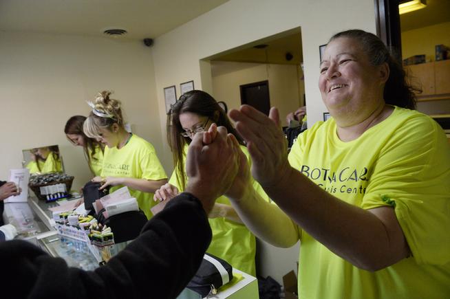 Co-owner Robin Hackett is congratulated by a friend at BotanaCare 21+ in Northglenn, where the retail marijuana center opened to a line of people Jan. 1. Hackett's partner is sister Cheri Hackett. (Photo By Craig F. Walker / The Denver Post)