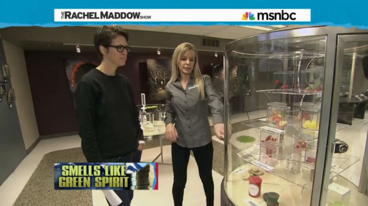 Rachel Maddow looks at her first display case of marijuana-infused edibles at Euflora's downtown Denver pot shop. (MSNBC)