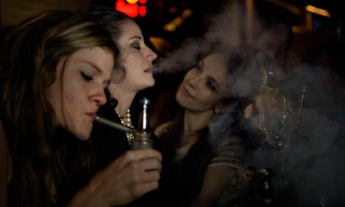 Amalia Janisch, center, exhales at the crowded dab bar during the "Prohibition is Over!" party at Casselman's Bar on Dec. 31, 2013 in Denver. (Joe Amon, Denver Post file)  