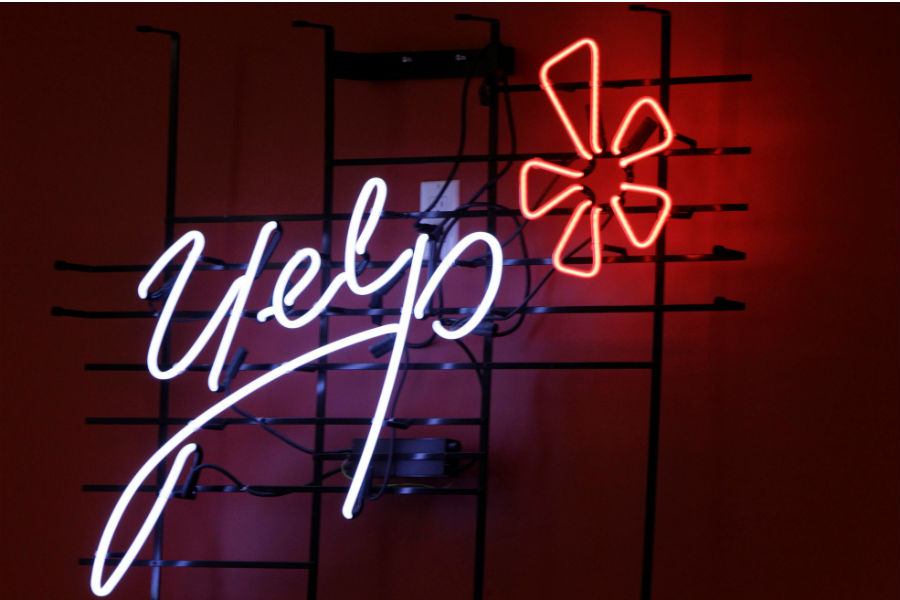 In this Oct. 26, 2011 file photo, the logo of the online reviews website Yelp is shown in neon on a wall at the company's Manhattan offices in New York. (Kathy Willens, AP file)