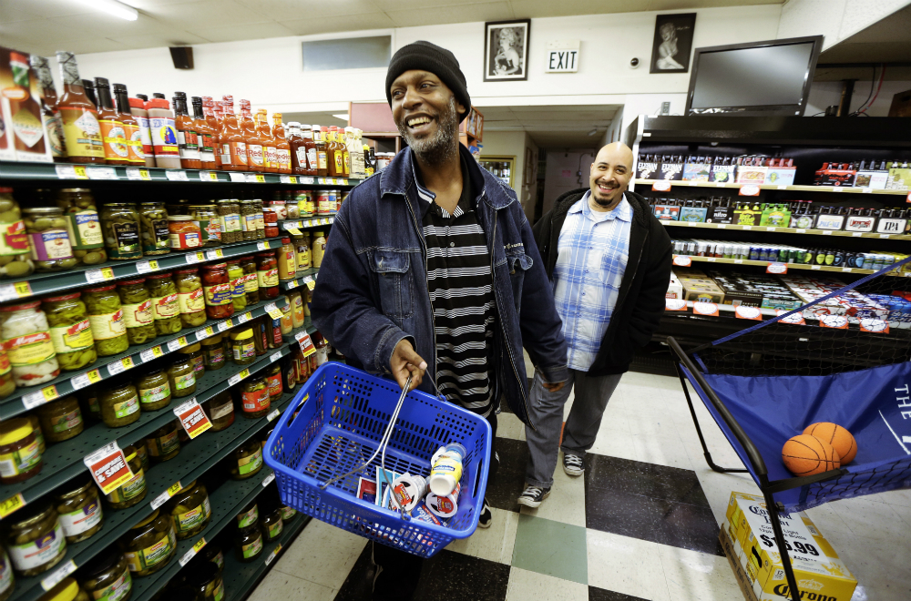 In this March 25, 2016 photo, Jerald Brooks, left, one of the original participants in a Seattle program called Law Enforcement Assisted Diversion, or LEAD, goes shopping for groceries with Chris Cates, right, his caseworker, in Seattle. Funding from the expansion of Medicaid brought on by President Barack Obama's health care law in some states has made repeat drug offenders such as Brooks eligible for coverage, which could be a new tool for shifting addicts out of the criminal-justice system as an alternative to the drug war. (Ted S. Warren, AP)