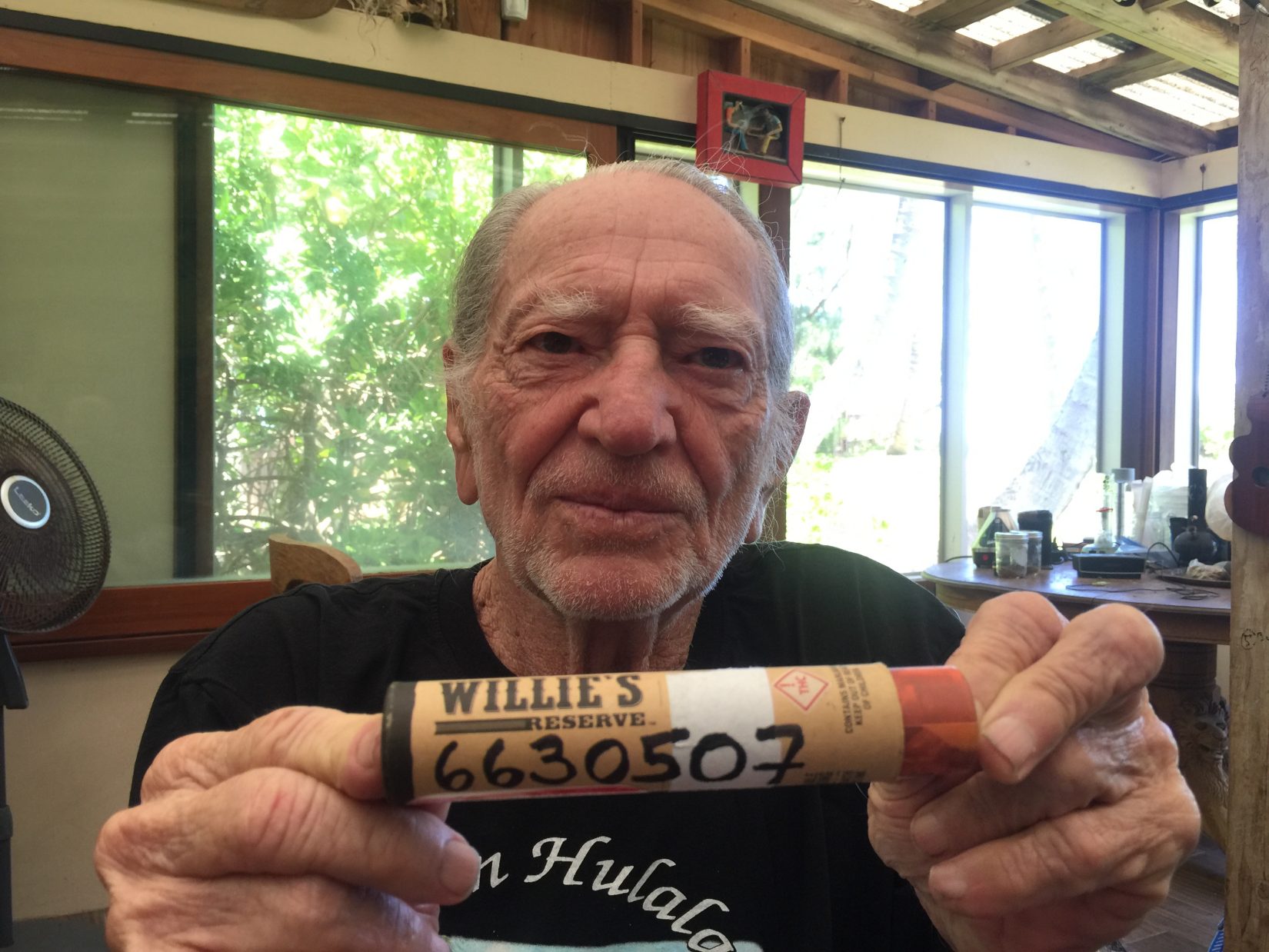 Willie Nelson holds up a container of his branded marijuana with "6630507" written on it. Following the U.S. Drug Enforcement Administration's inaction on rescheduling marijuana, legalization proponents have responded by taking to the internet to highlight Patent No. 6,630,507, which covers the potential use of non-psychoactive cannabinoids. (Photo courtesy of Willie's Reserve)