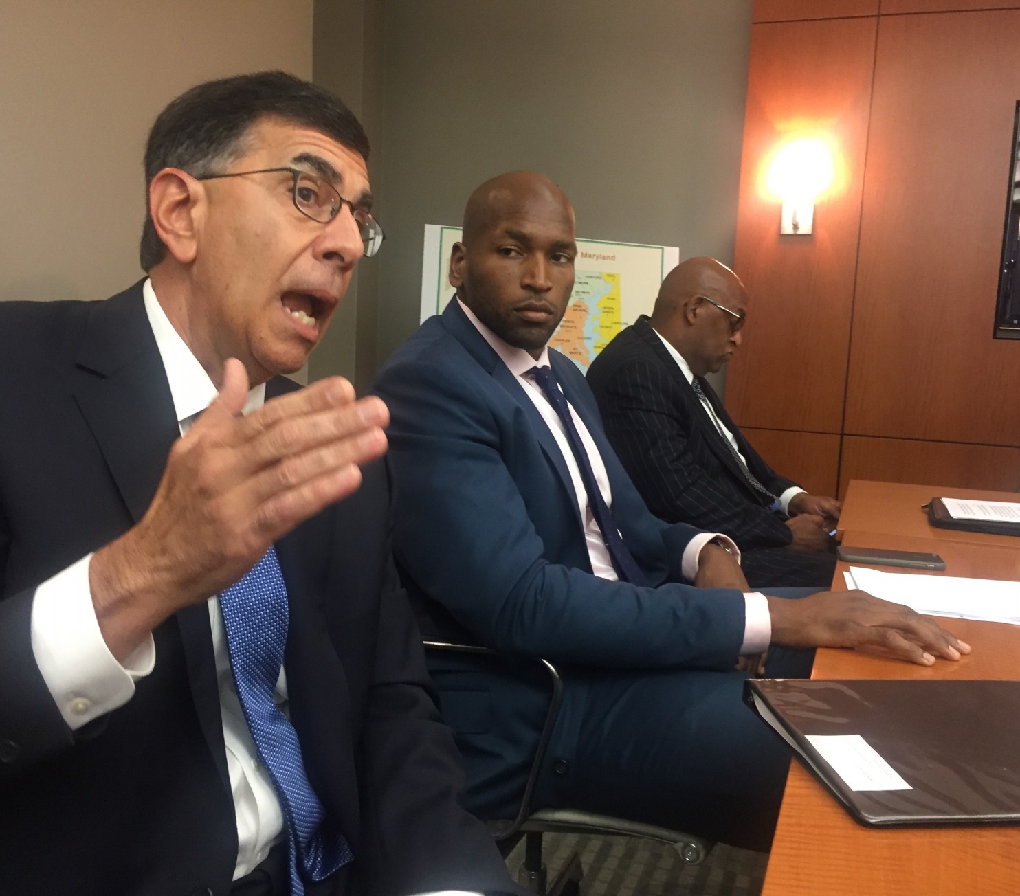 Medical marijuana investor and former Baltimore Ravens tackle Eugene Monroe, center, listens as Phil Andrews, his company's lawyer, tells reporters why Green Thumb Industries is suing Maryland. To the right is GTI general manager Sterling Crockett. (Fenit Nirappil, The Washington Post)