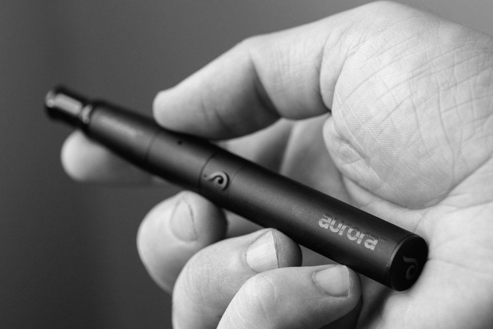 A black and white photo of the Dr. Dabber Aurora being held in a hand.